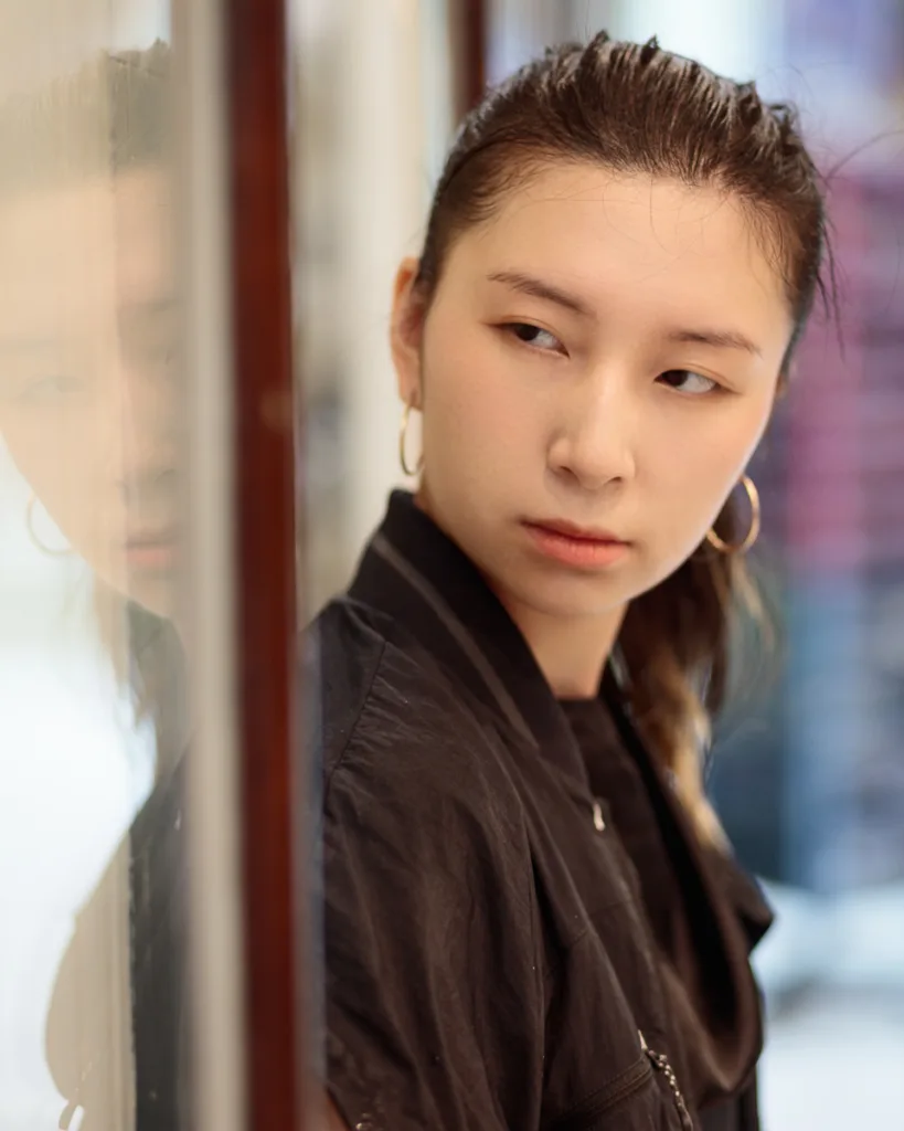 Woman in black jacket near glass reflection