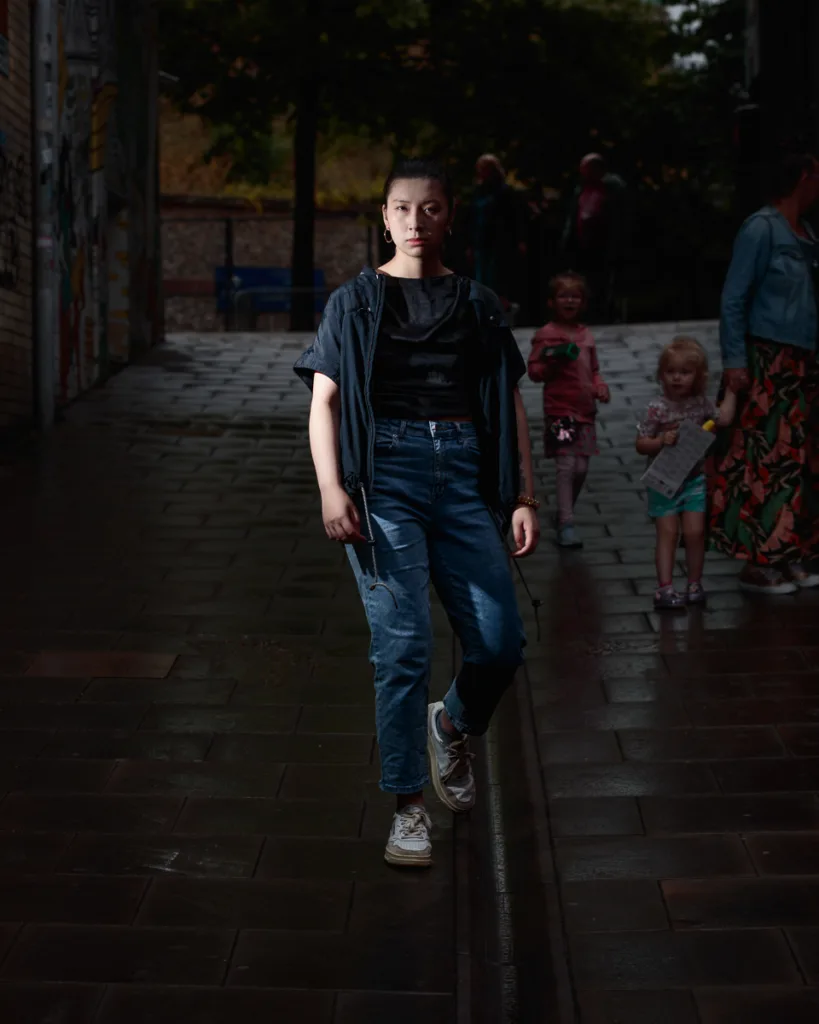 Person walking on dimly lit brick pathway.