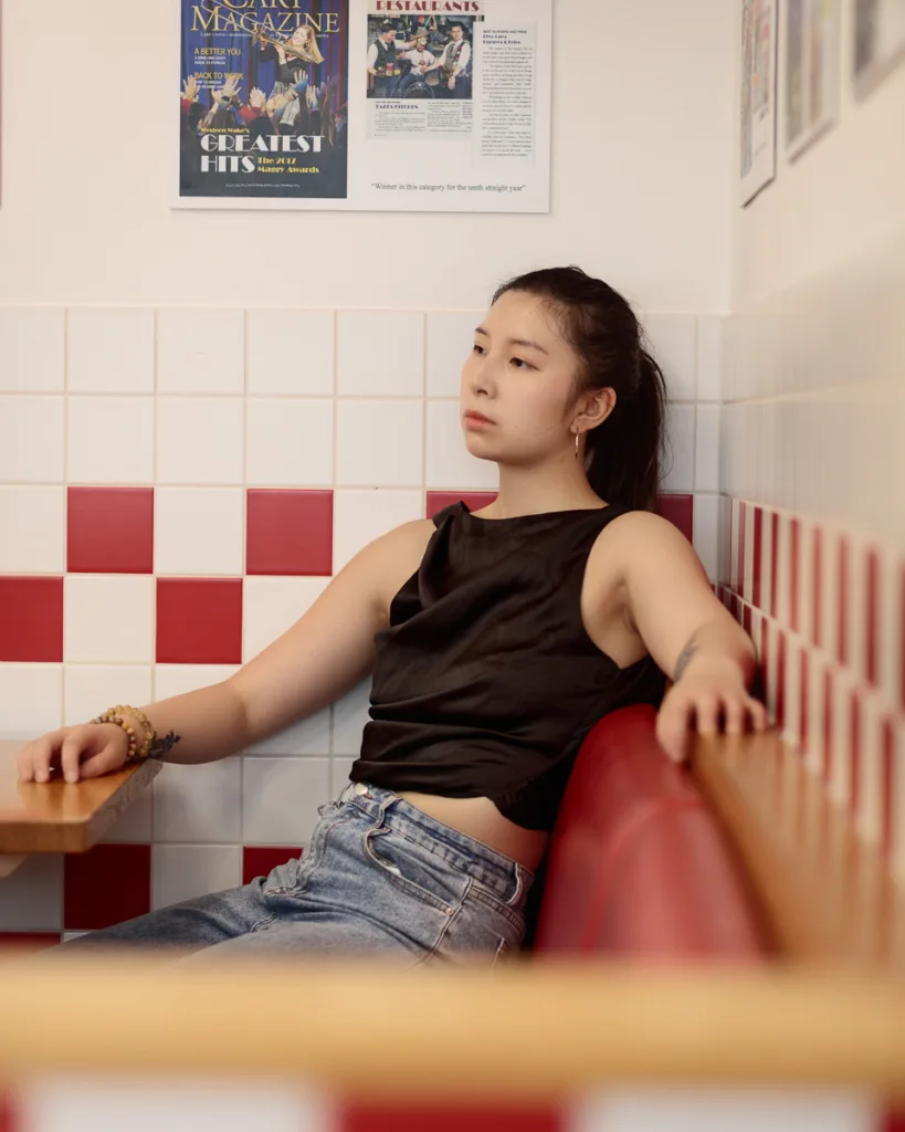 Person relaxing in a diner with magazine decor.