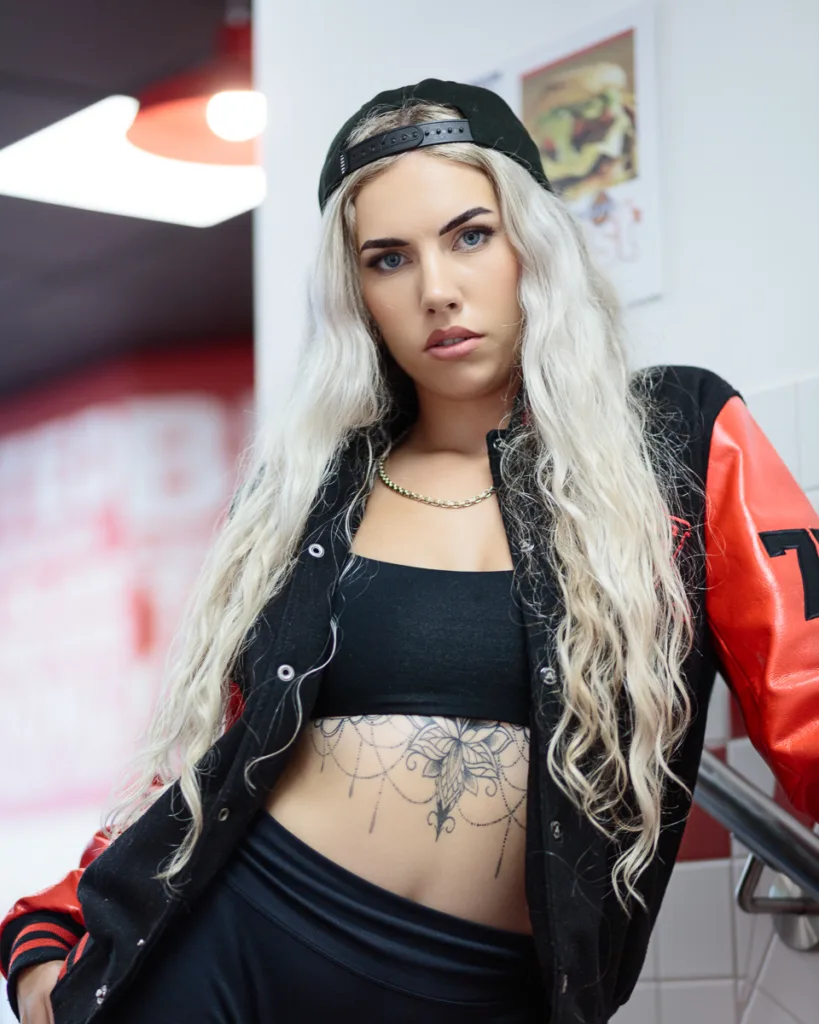 Person in cap and jacket with tattooed stomach.