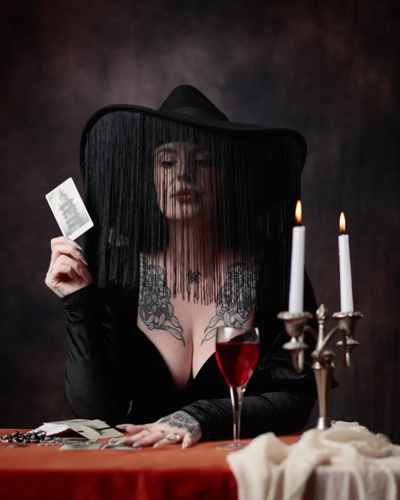 Mystic with veil, tarot card, candles, and wine.