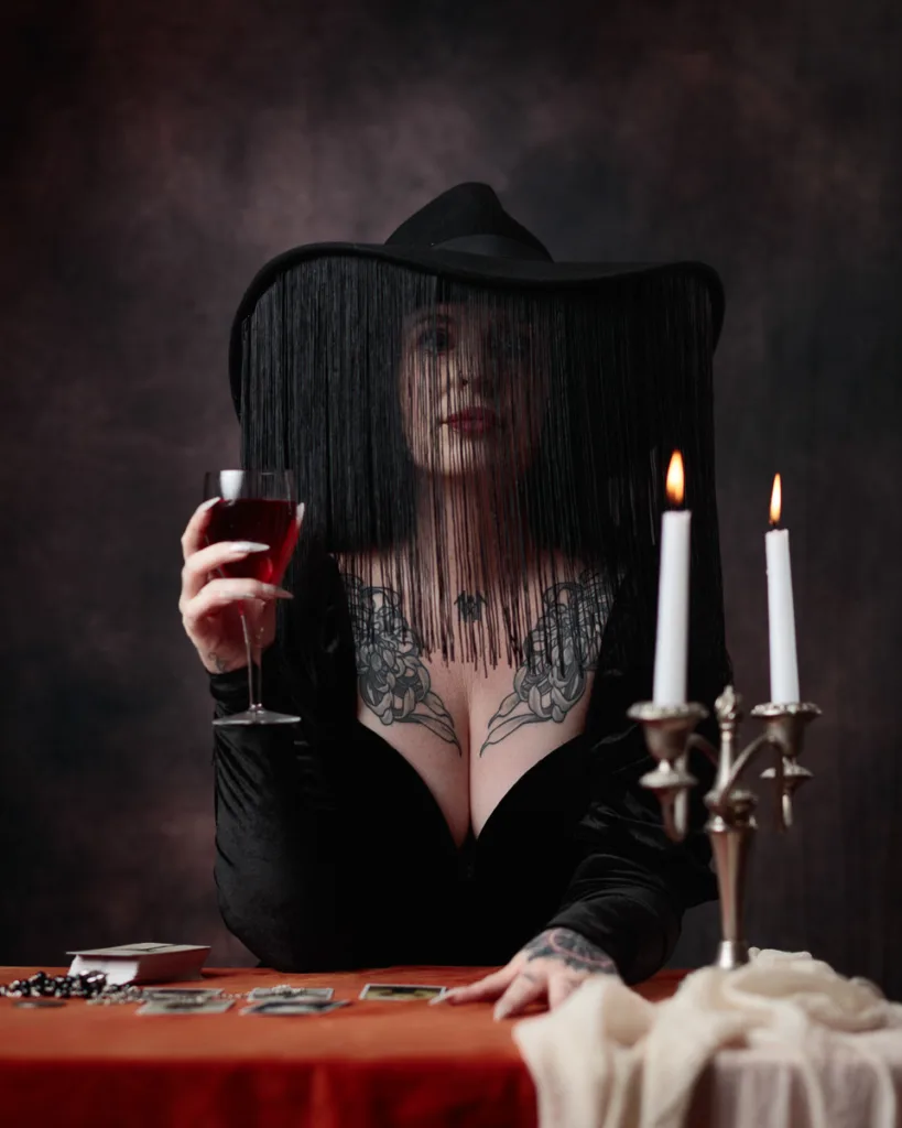 Mysterious woman with hat, wine, and tarot cards.