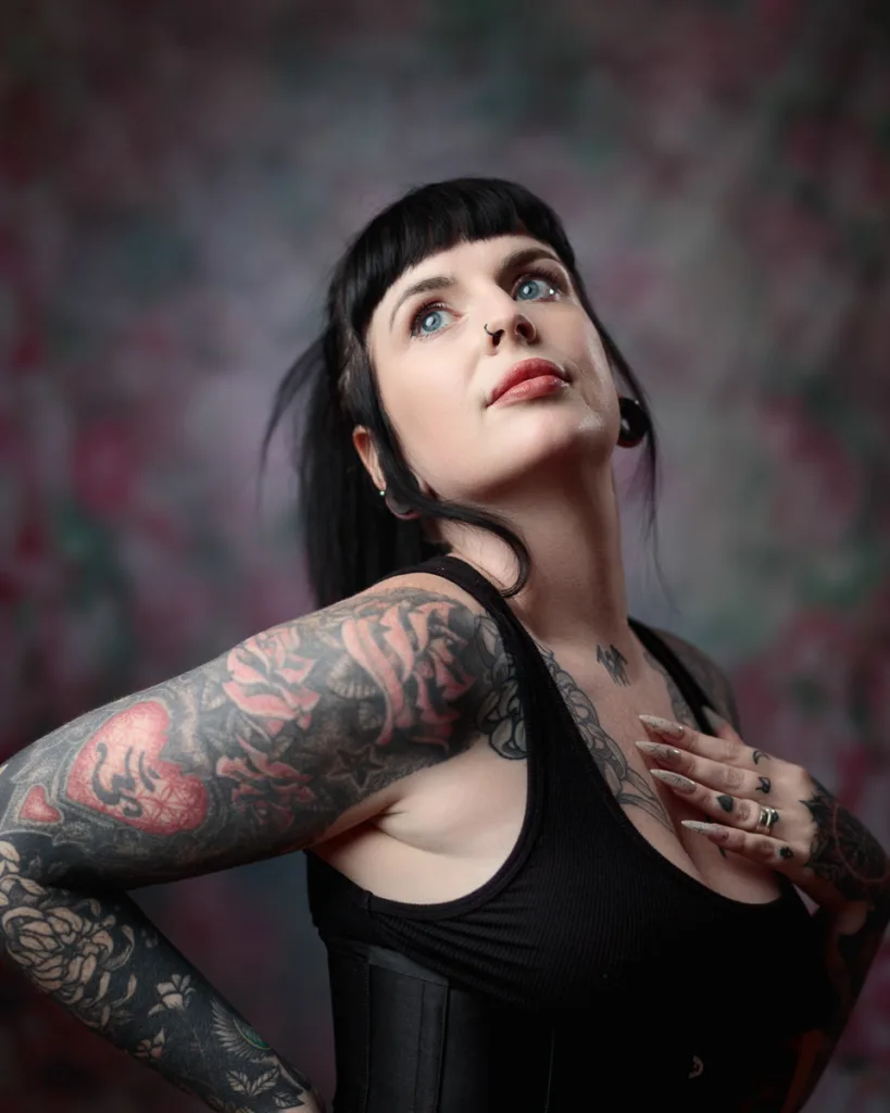 Tattooed person posing with thoughtful expression.