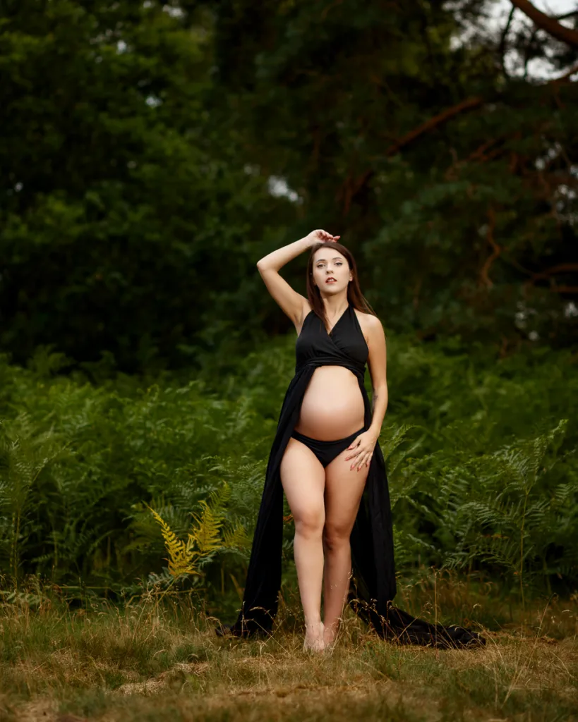 Pregnant woman in black dress, nature background.