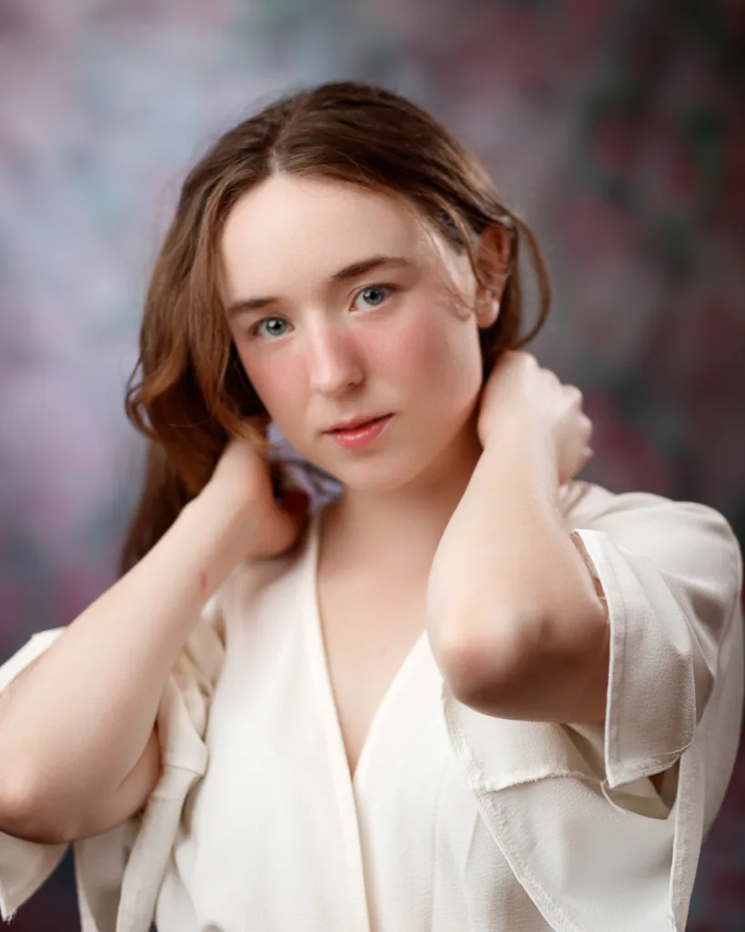 Person with hands near neck, soft background.
