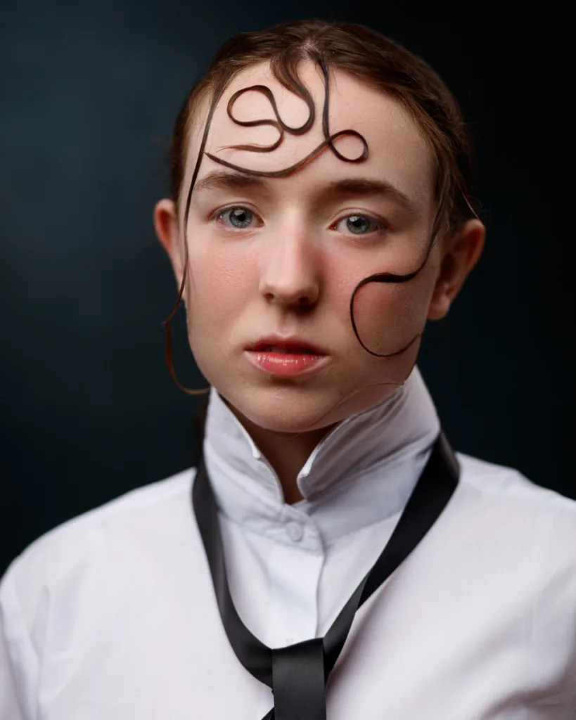Person with unique hairstyle and white collar shirt.