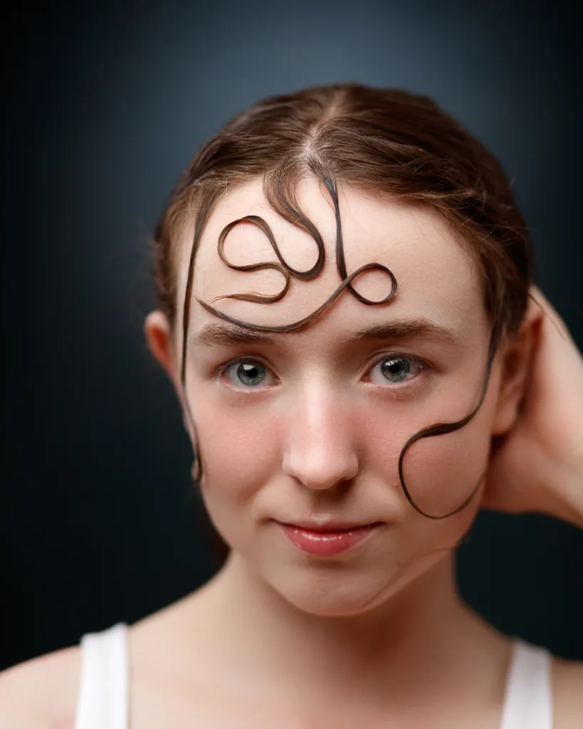 Woman with artistic hair loops on forehead.