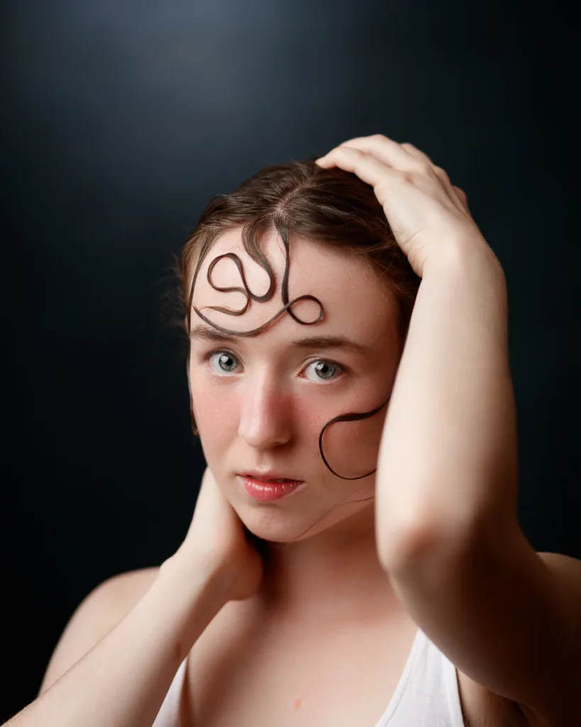Woman with hair swirls on her face.