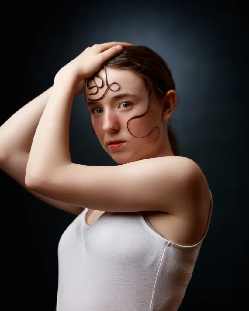 Woman posing with hand on head, artistic portrait