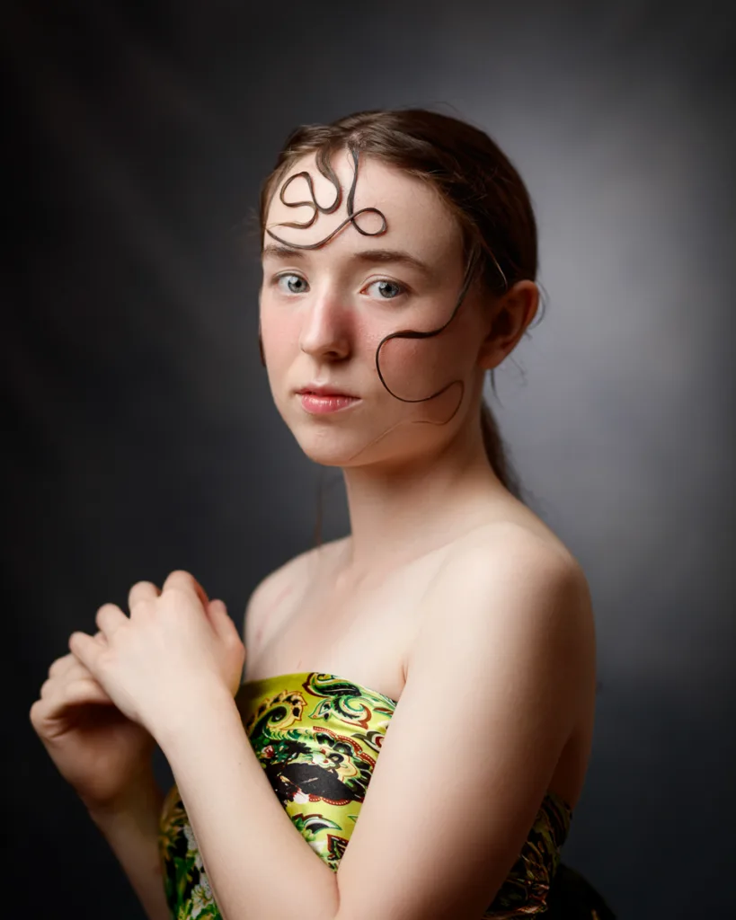 Woman in patterned dress with artistic hairstyle.