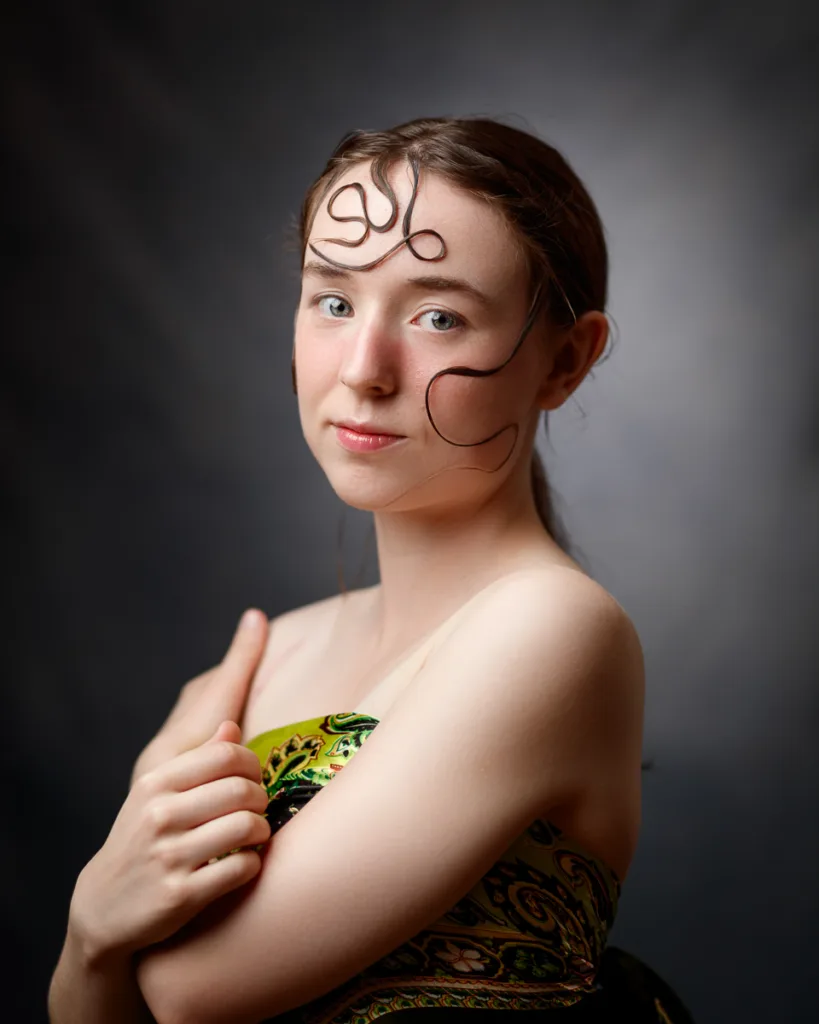 Woman with ornate hair design and artistic dress.