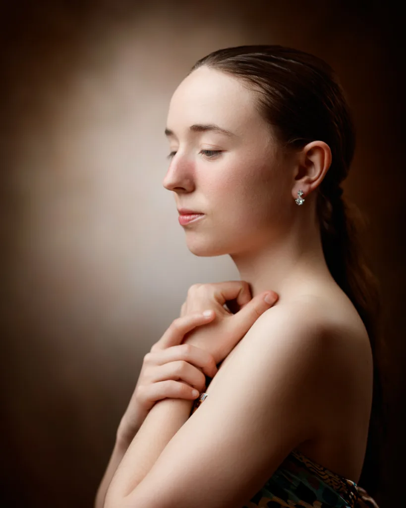 Portrait of serene woman with hands clasped.