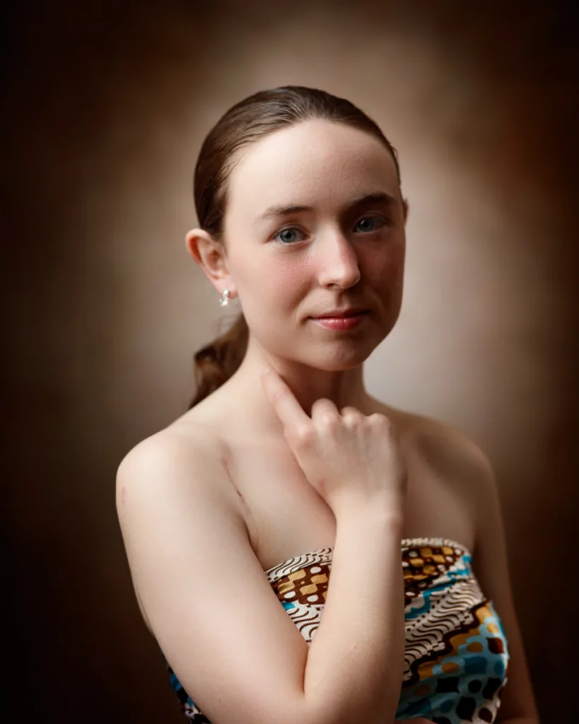 Portrait of woman in patterned top, thoughtful expression.