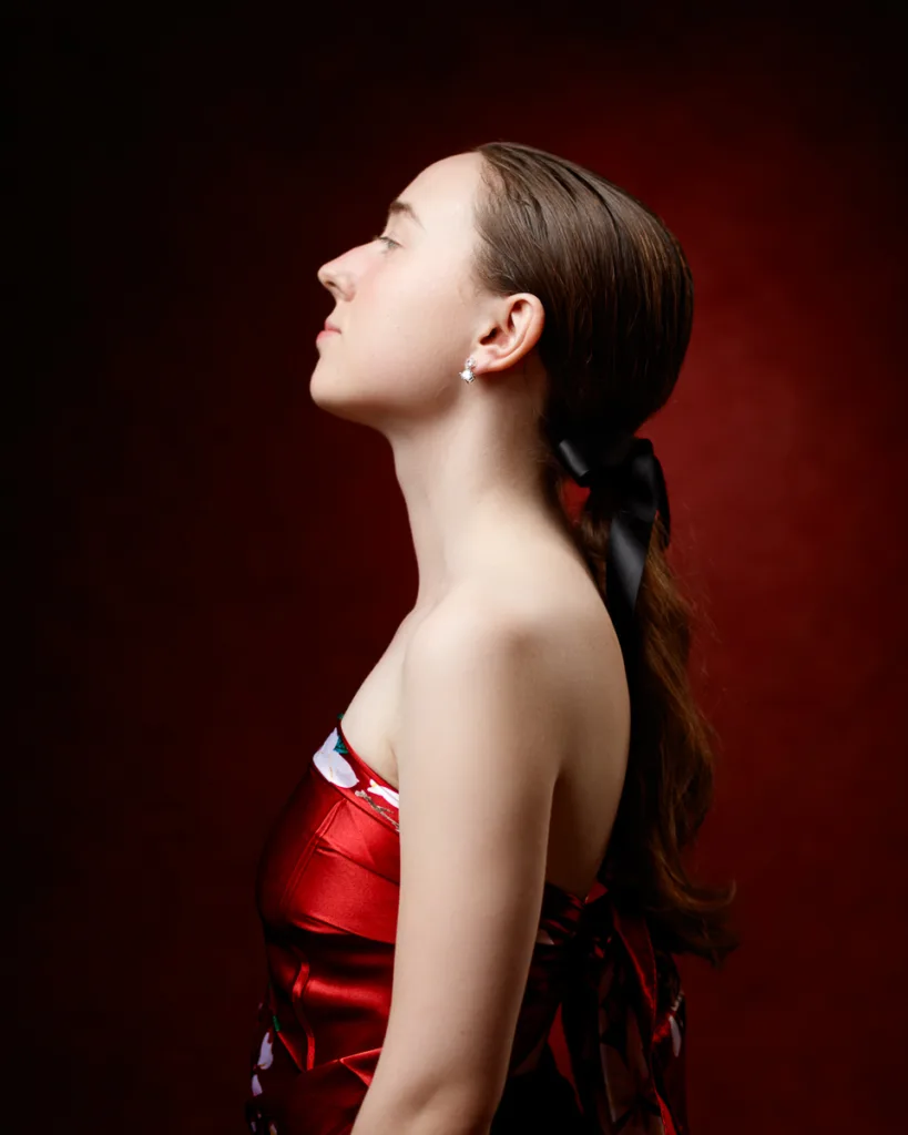 Woman in red dress with side profile view