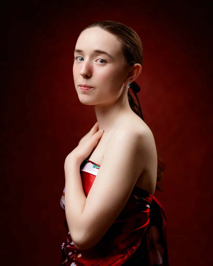 Woman in red dress with hand on chest