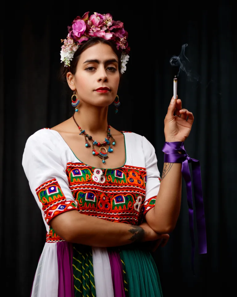 Woman in colourful dress with flower crown smoking