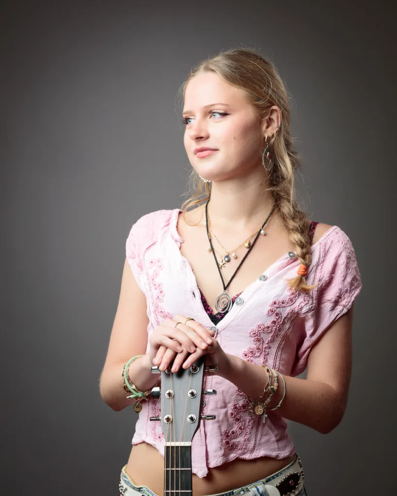 Woman with braided hair holding a guitar