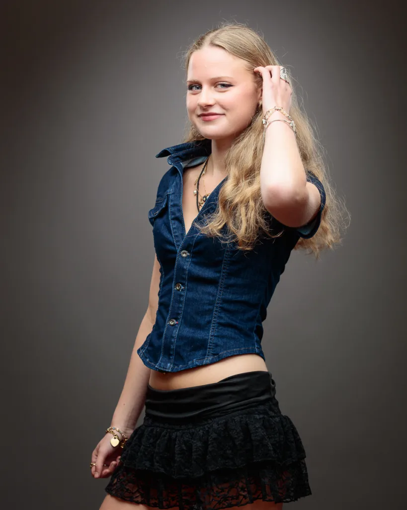 Woman in denim shirt, lace skirt smiling