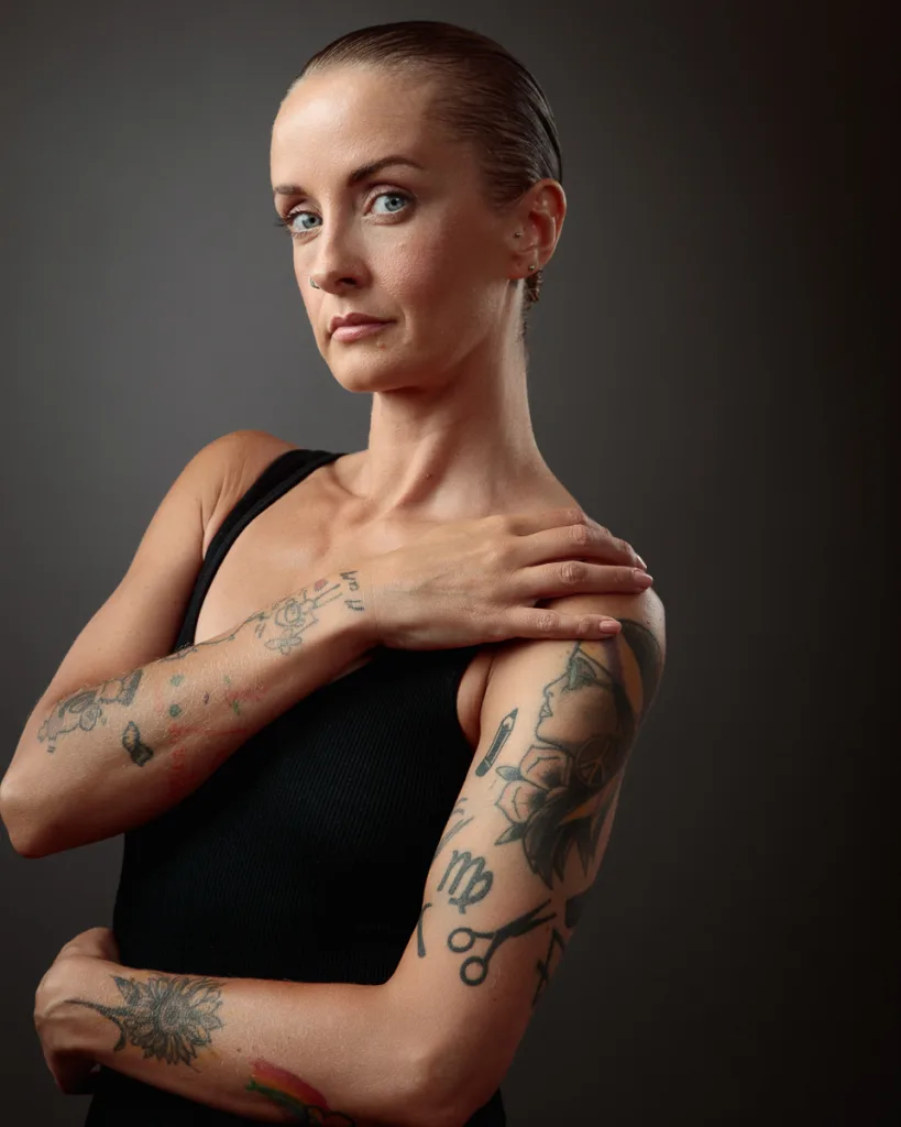 Woman with tattoos wearing a black top.