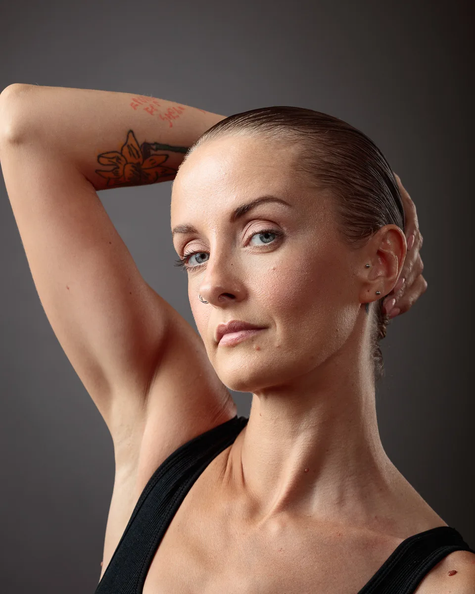 Person with tattoo posing confidently, arm raised.
