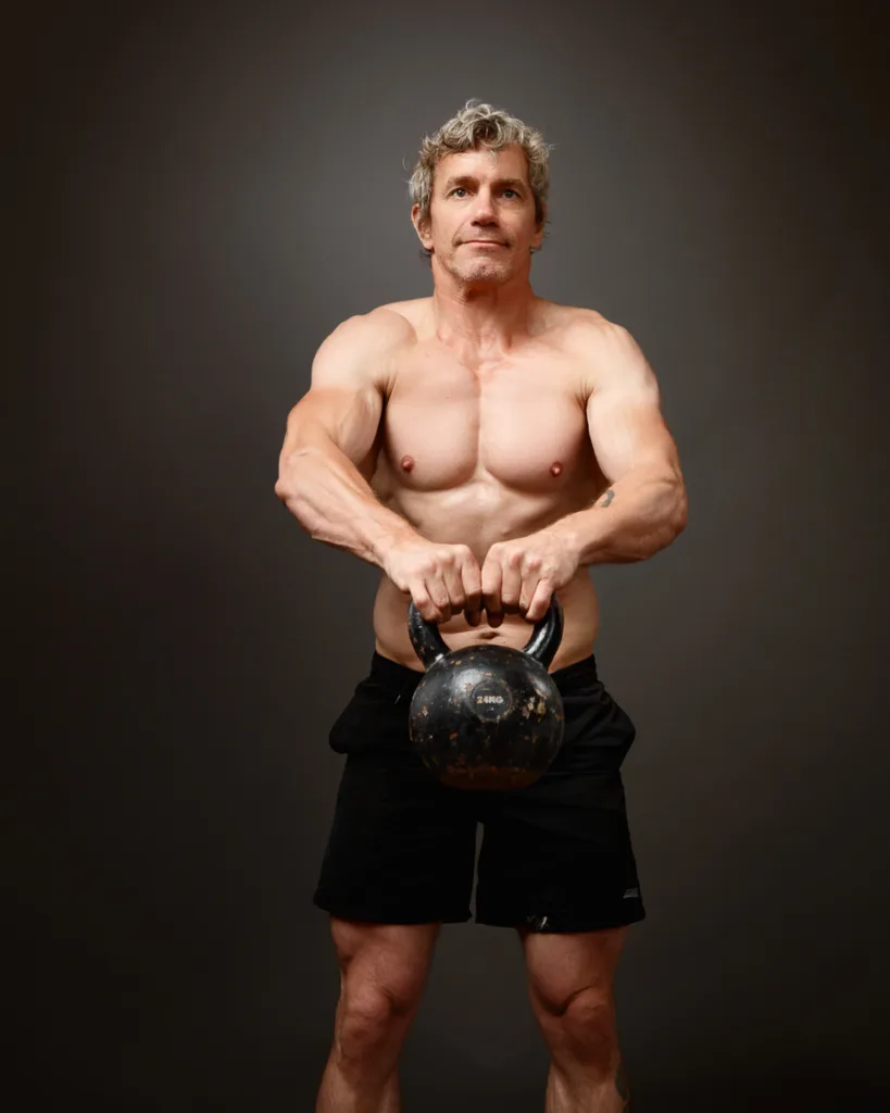 Man lifting kettlebell in fitness studio