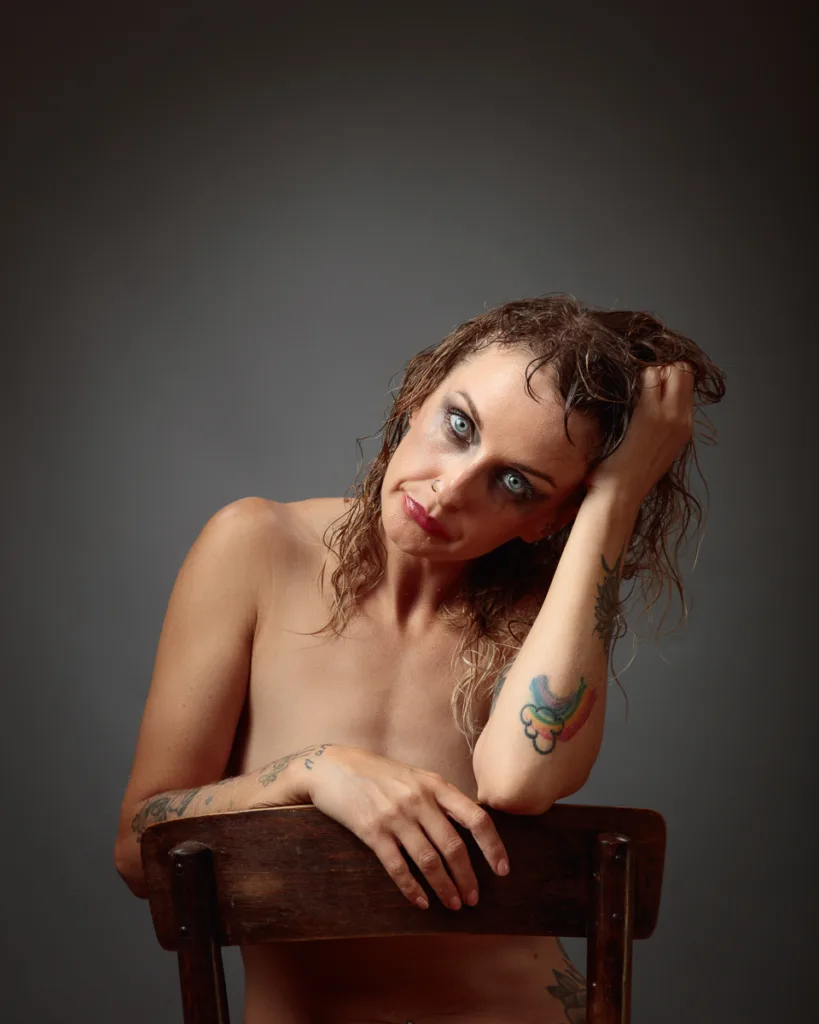 Artistic studio portrait of Michelle leaning on a wooden chair with wet hair