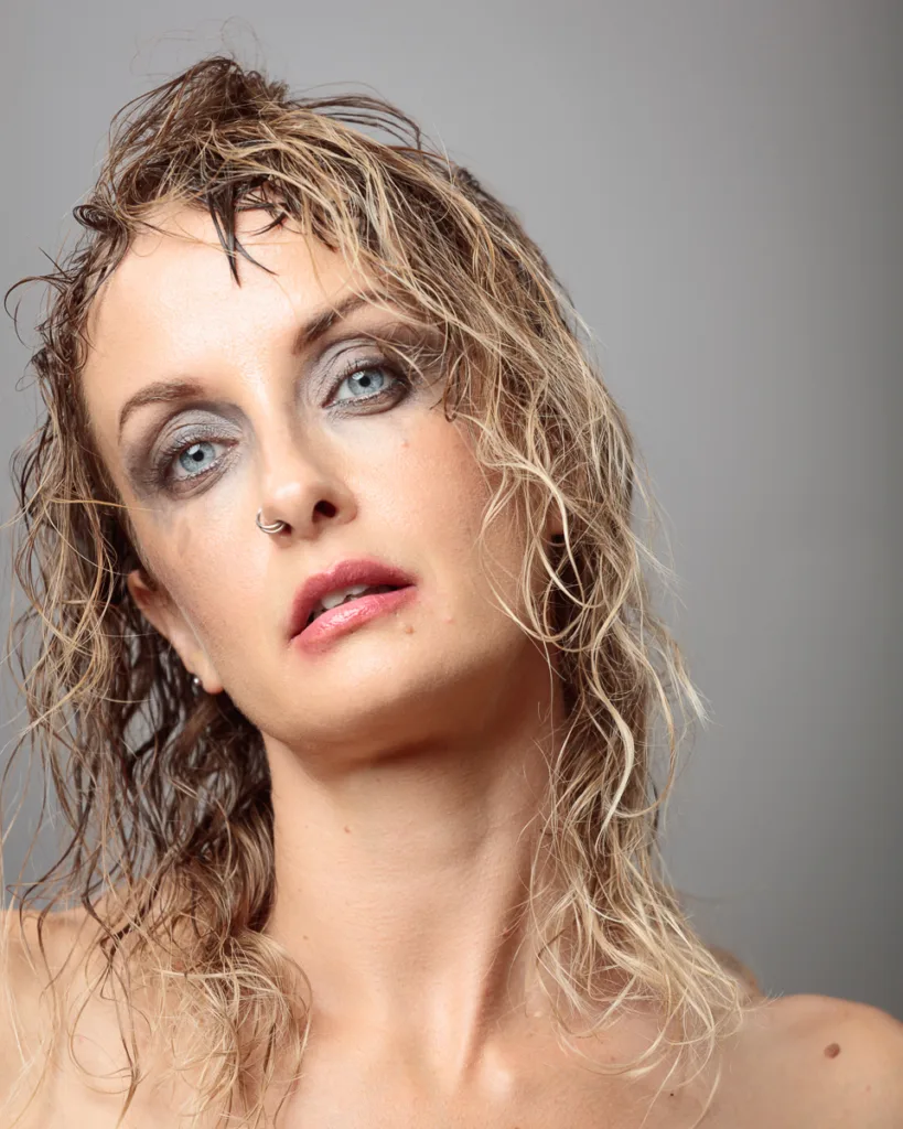 Woman with wet hair and dramatic makeup.
