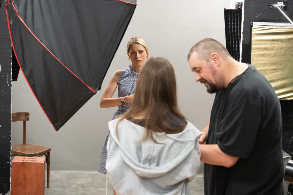 Photography studio setup with three people interacting.
