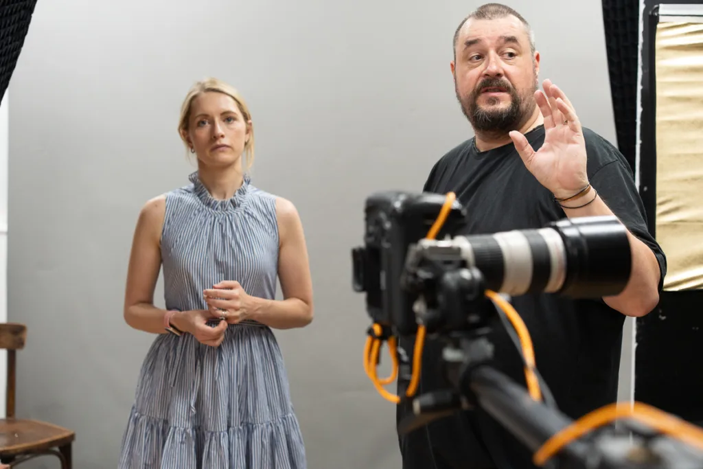 Photographer instructs model during studio photoshoot.
