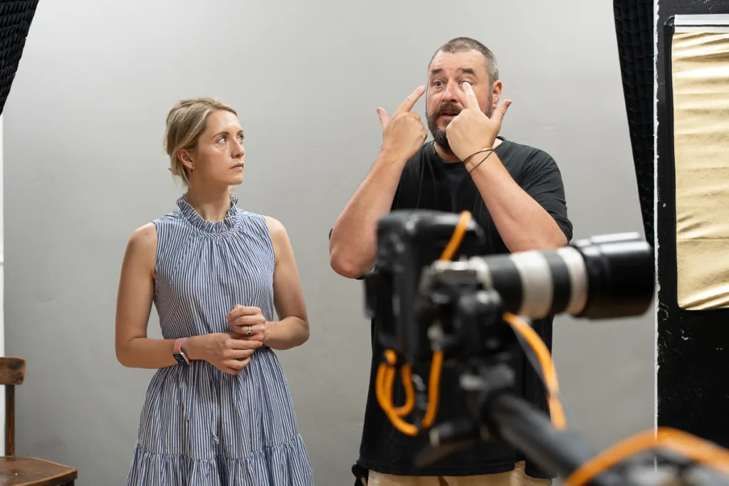 Photographer explaining technique to model in studio.