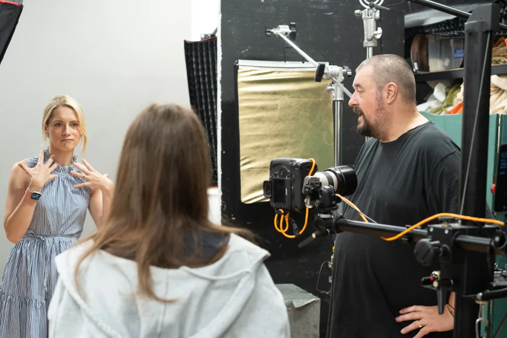 Photographer directing team in studio setting.