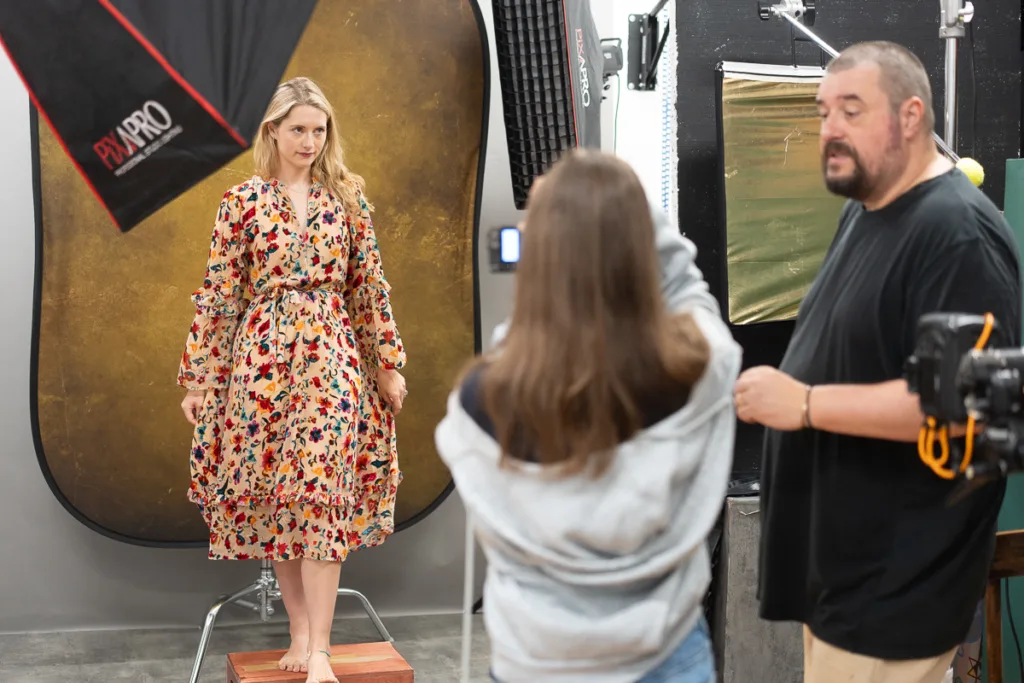 Model in floral dress during a photoshoot session.