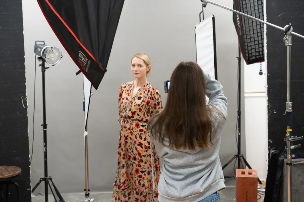 Photographer taking a portrait of woman in studio.
