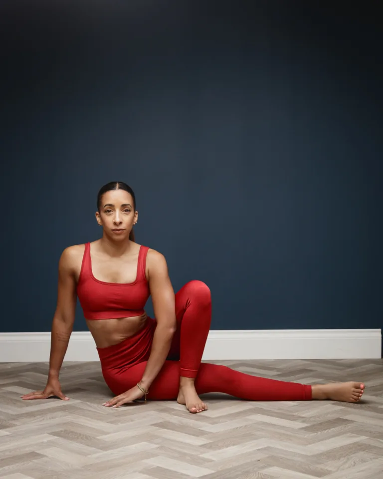 Woman in red activewear stretching on a herringbone floor