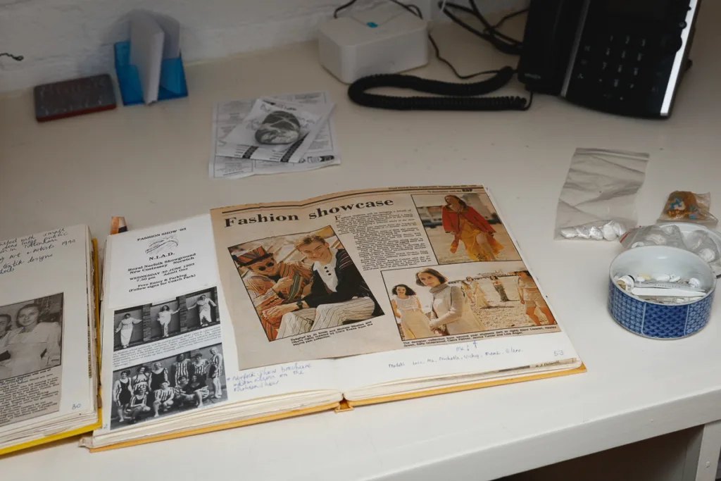 Open scrapbook with newspaper clipping on fashion showcase.