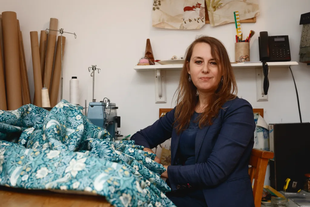Woman sewing with fabric and sewing machine.