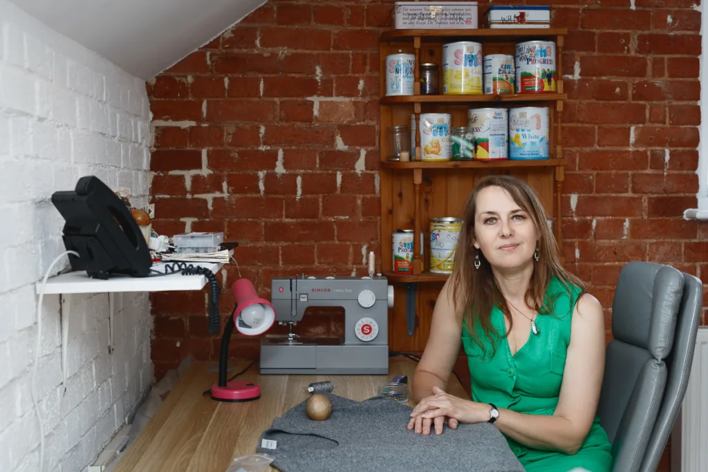 Woman sewing at desk with sewing machine.