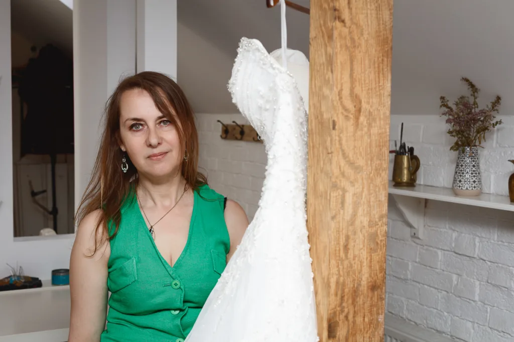 Woman in green top with white dress displayed.