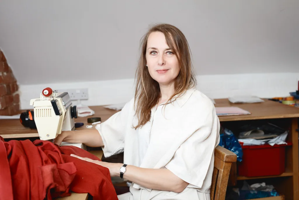 Woman sewing red fabric on a sewing machine