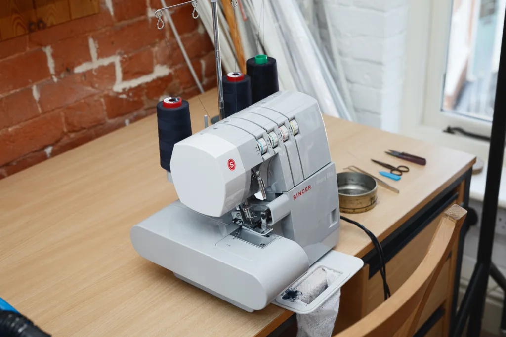 Overlocker sewing machine on wooden table.
