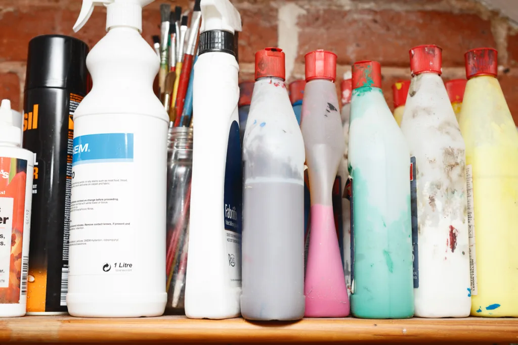 Assorted paint bottles on a shelf