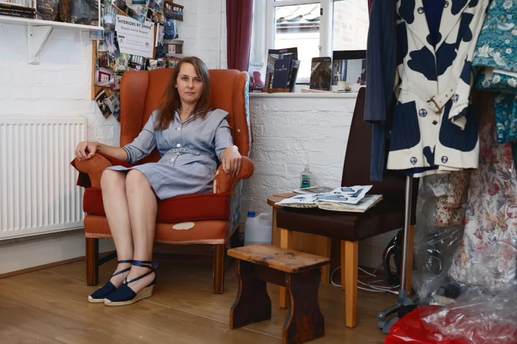 Woman in a workshop with fabrics and sewing materials.