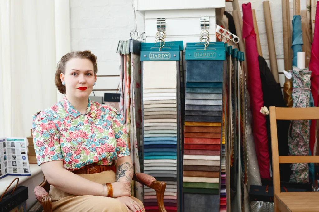 Woman in shop with fabric samples and chairs