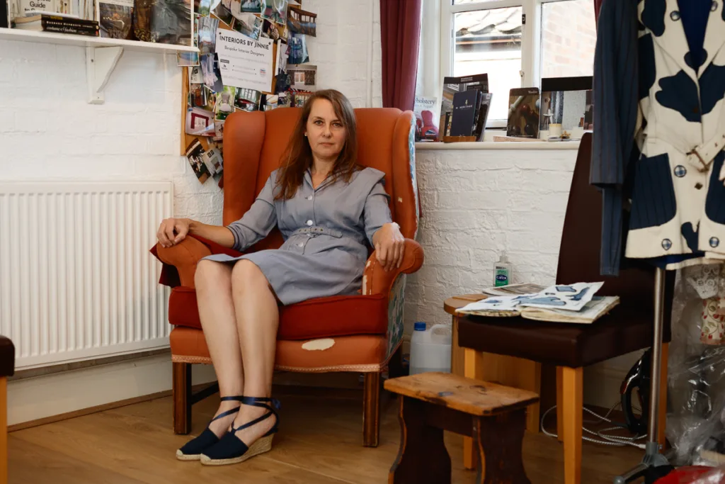 Woman in armchair inside a cosy room setting.