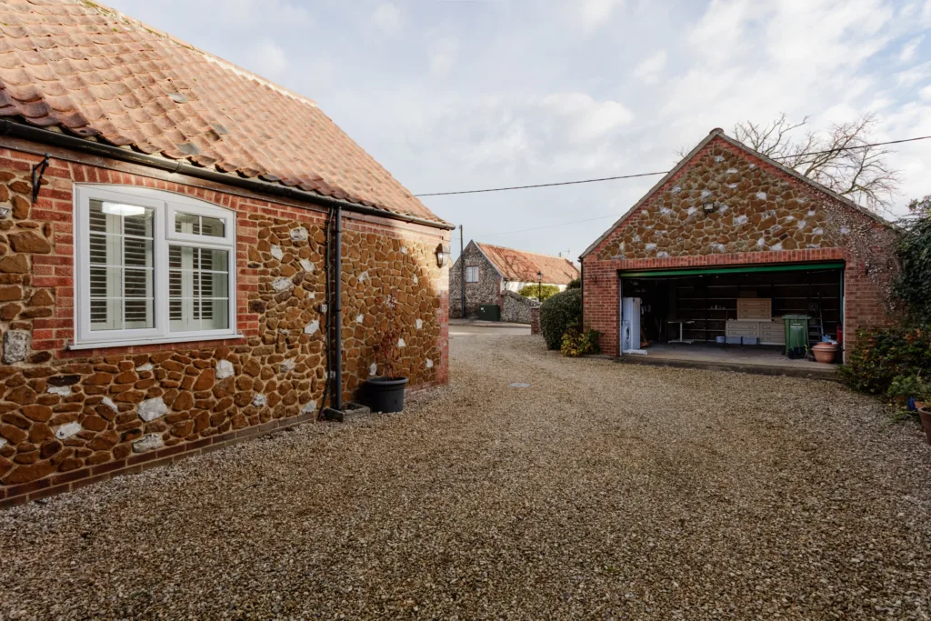 Traditional stone cottages with gravel driveway.