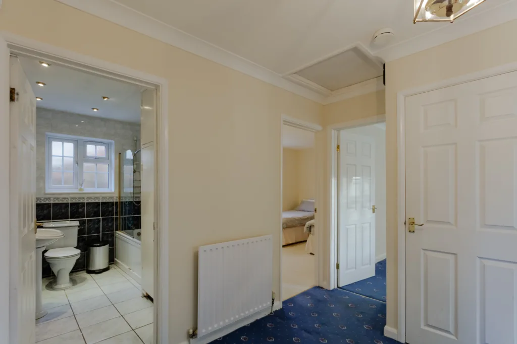 Hallway with bathroom and bedroom doors open.