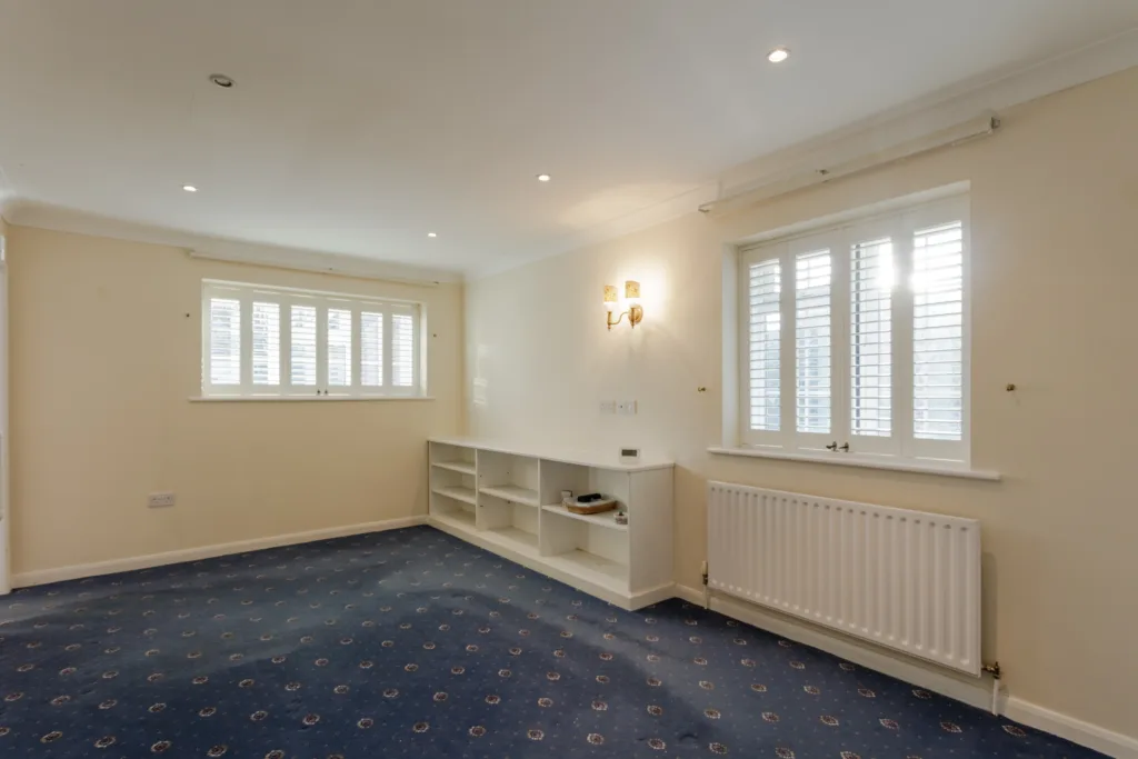 Empty room with windows and blue carpet