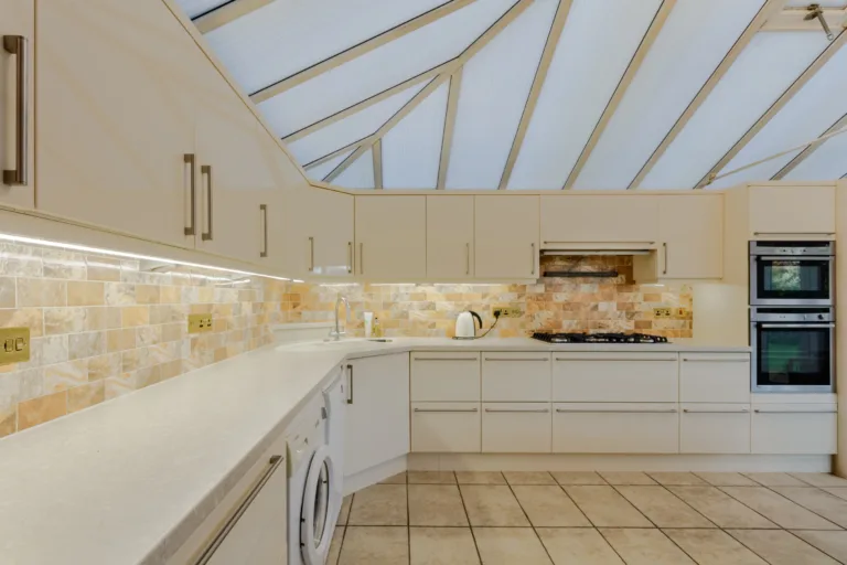 Kitchen with cream units and a glass roof in a property at Ringstead