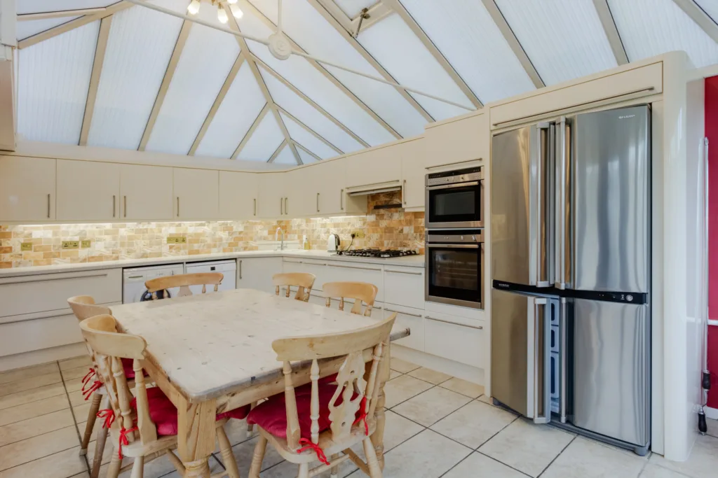 Modern kitchen with dining table and appliances.
