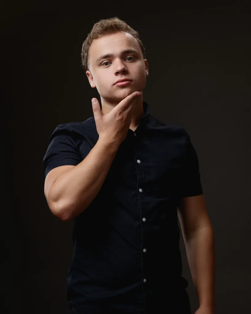 Person posing in dark shirt, thoughtful expression.